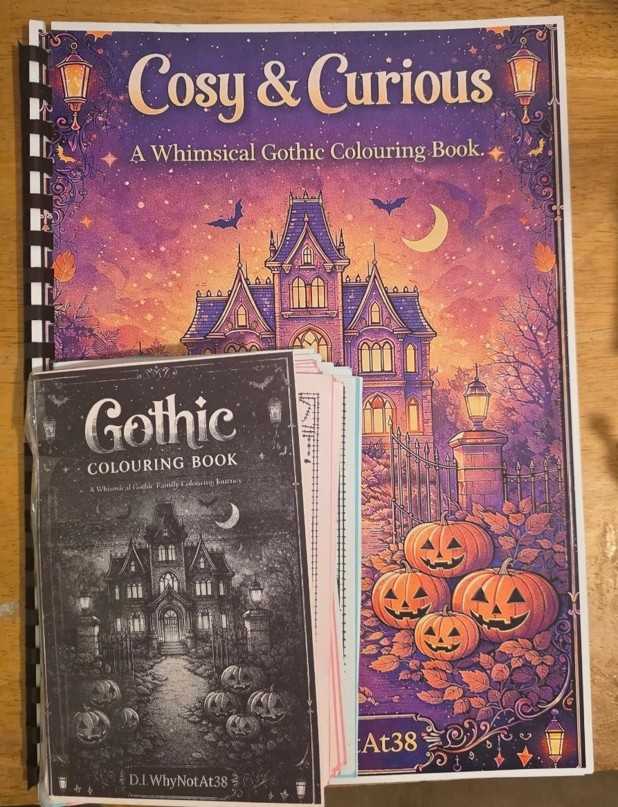 Two Gothic coloring books with pumpkins and a haunted house on a wooden surface.